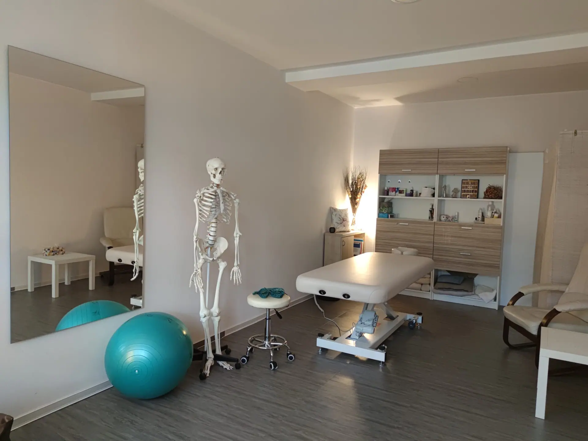 Terapeutická místnost ve Zlíně s masážním lehátkem, gymnastickým míčem a anatomickým modelem